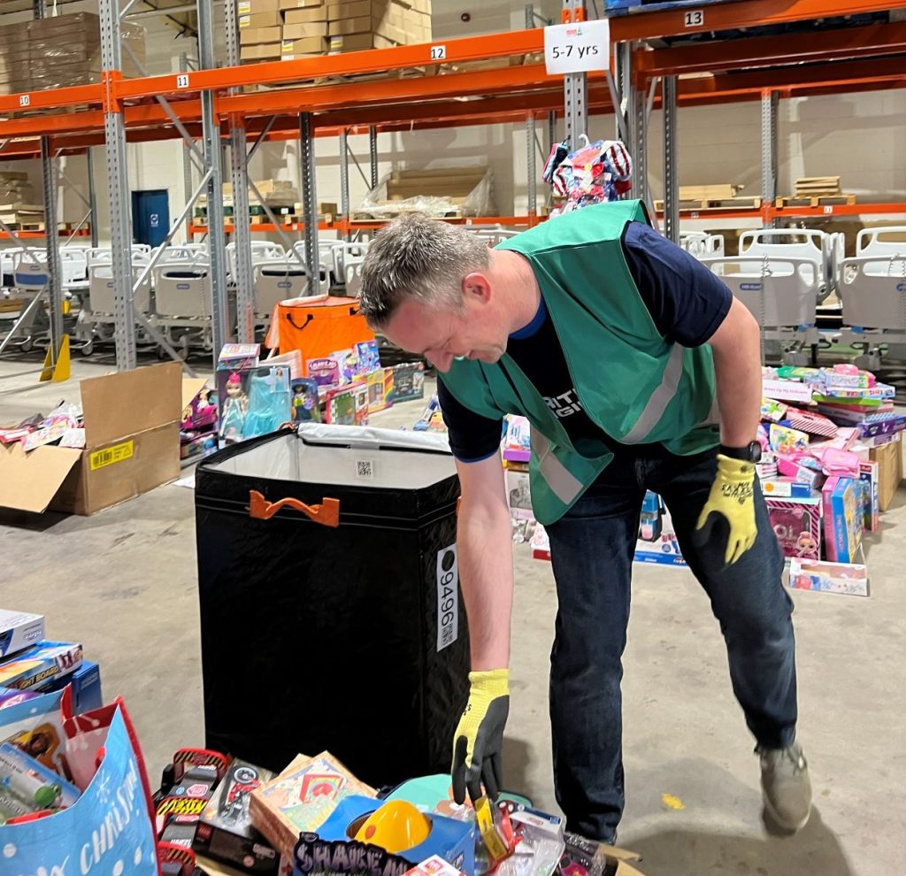 Cash for Kids Mission Christmas Volunteer sorting toys